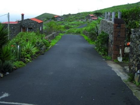 Camino flanqueado por edificios construidos con material volcánico