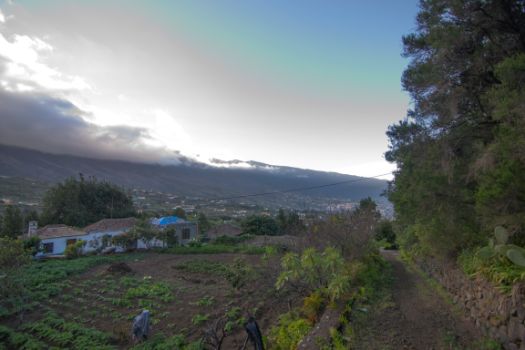 El sendero discurre entre muretes de piedra y viviendas y cultivos