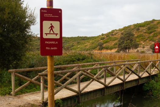 Pasarela peatonal de madre sobre el río Jardín