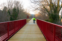 Cycle tourist cycling along one of the viaducts over the river Nela